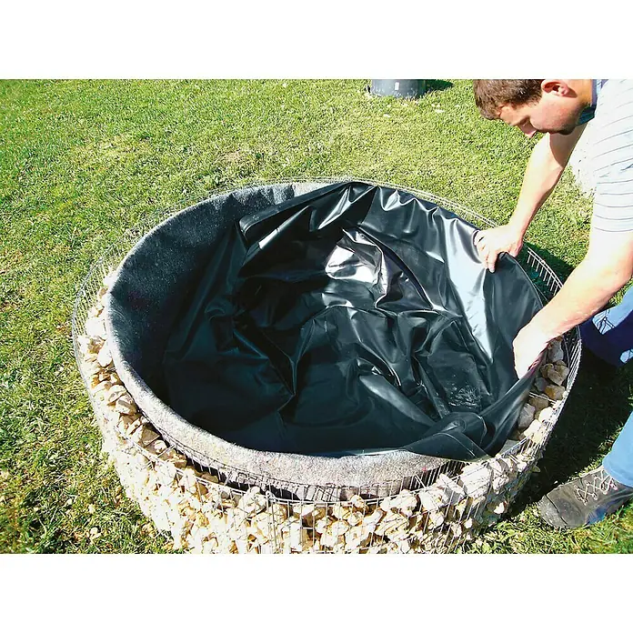 Bellissa Gabionen-Hochteich Bausatz - 146 x 40 cm, Metall - Die Installation einer Teichfolie in einem runden, mit Steinen befüllten Teich. Das Projekt wird von einer Person durchgeführt.