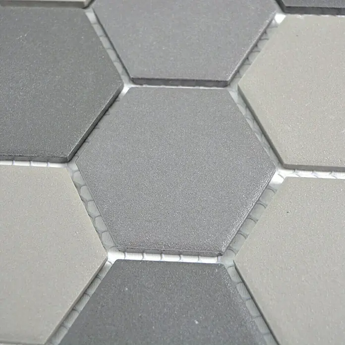 Mosaikfliese Hexagon Mix CU HX160 - 32,5 x 28,1 cm, Grau/Schwarz, Matt - Nahaufnahme von grauen, sechseckigen Fliesen, die auf einem Netz befestigt sind, ideal für moderne Wand- und Bodengestaltungen im Innenbereich.