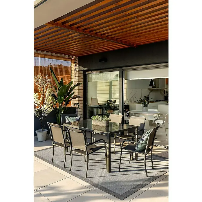 Conjunto de muebles Leila - 7 pzs., Textiline/Acero, Antracita - Área de comedor al aire libre con una elegante mesa de comedor y sillas bajo una moderna pérgola de madera, creando un ambiente elegante y acogedor.