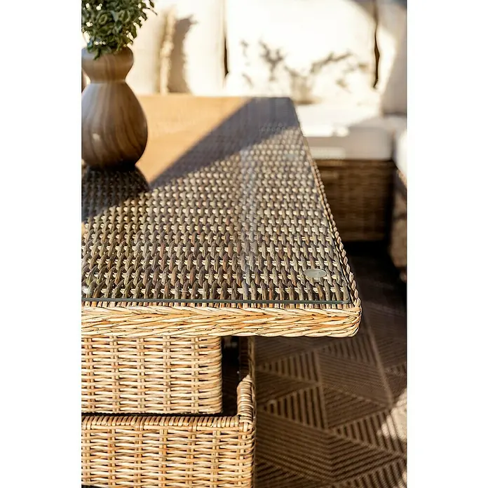 Mesa de jardín Gotland - L x An x Al: 134 x 84 x 68 cm, Aluminio/Ratán sintético, Arena - Primer plano de una mesa de mimbre con tapa de cristal, que destaca la textura y el diseño del mueble.