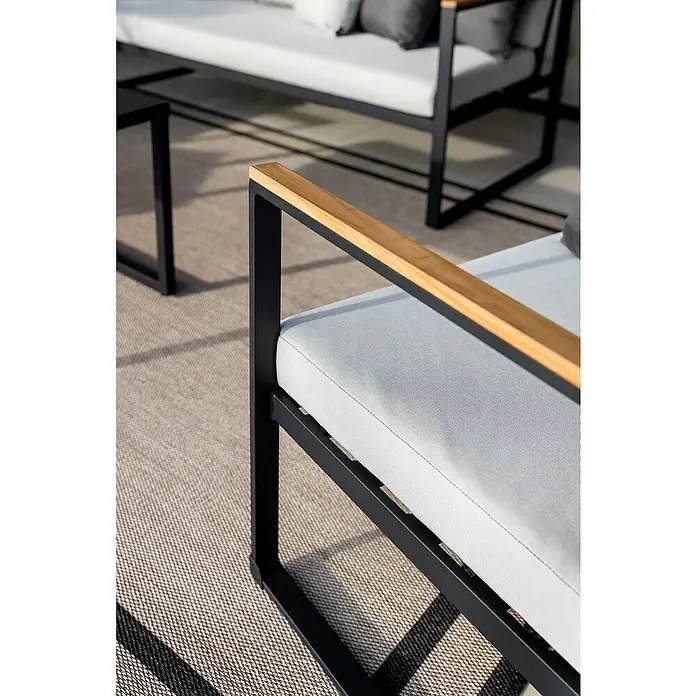 SENSUM Conjunto de muebles Inari - 5 pzs., Aluminio, Negro - Vista detallada de un moderno sofá de exterior con estructura negra, cojines gris claro y reposabrazos de madera.