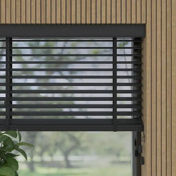 Jalousie BambusB x H: 90 x 130 cm, Schwarz, Holz - Schwarze Jalousien vor einem Fenster mit Blick auf eine grüne Landschaft, die für Privatsphäre und Schatten sorgt. Das Holzpaneel ergänzt das moderne Design.