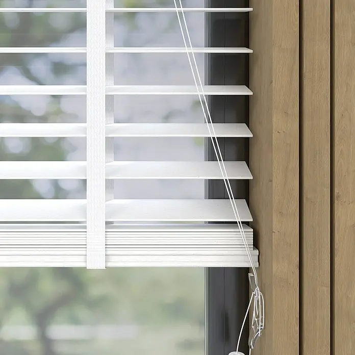 Jalousie BambusB x H: 90 x 175 cm, Weiß, Holz - Nahaufnahme von weißen Holzjalousien, die durch ein Fenster mit Blick auf einen Garten Licht hereinlassen und Privatsphäre bieten.