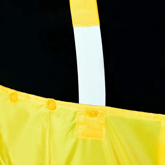 Regenlatzhose - M, 100% Polyester - Nahaufnahme einer gelben Sicherheitsweste mit reflektierenden Elementen und Druckknöpfen vor schwarzem Hintergrund.
