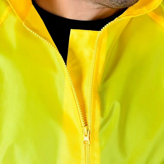 Regenjacke - M, 100% Polyester - Nahaufnahme einer gelben Regenjacke mit Reißverschluss, ideal für Outdoor-Aktivitäten und Schutz vor Regen.