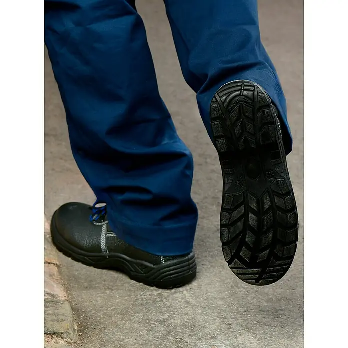 Sicherheitsstiefel Bob - Schuhgröße: 41, S3 - Ein Paar Sicherheitsschuhe in Schwarz werden auf einer grauen Oberfläche präsentiert, wobei die Sohle eines Schuhs deutlich sichtbar ist.