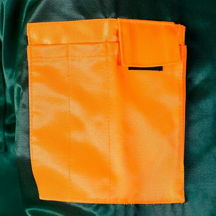 Forstblouson 4in1 - Grün/Orange, XXL - Nahaufnahme einer grünen Arbeitsjacke mit aufgesetzter, orangefarbener Tasche mit Klettverschluss.