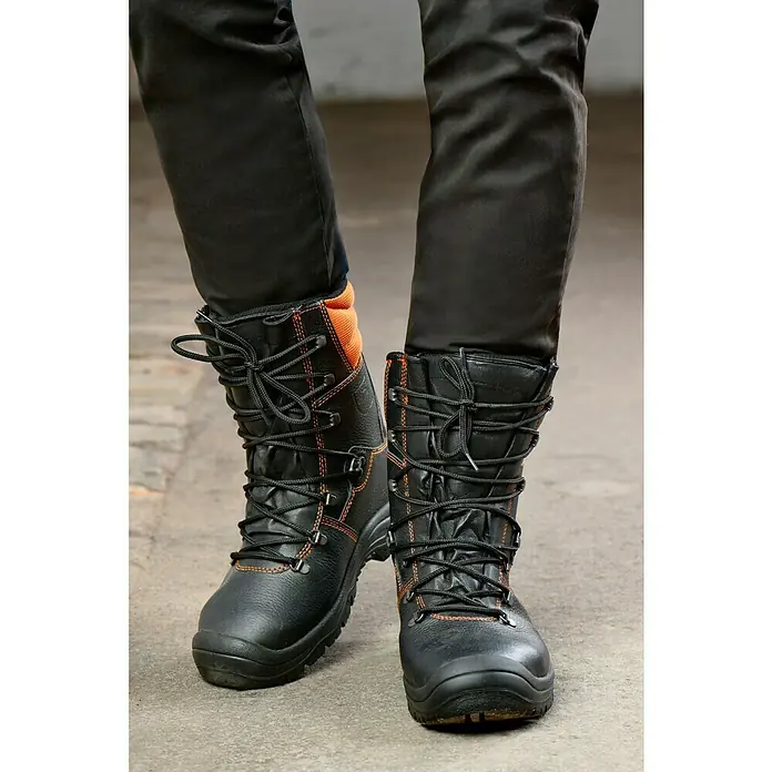 Stabilus Sicherheitsstiefel - 46, Orange/Schwarz - Das Bild zeigt ein Paar schwarze Arbeitsstiefel mit orangefarbenen Akzenten und Schnürsenkeln, die auf einem grauen Untergrund stehen. Die Stiefel sind robust und für den Einsatz im Beruf konzipiert.