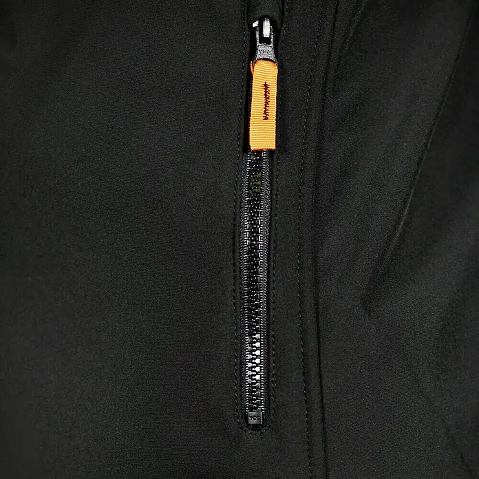 L.Brador Softshell-Jacke 554 P - Schwarz, XS - Detailaufnahme eines schwarzen Kleidungsstücks mit Reißverschluss und orangefarbenem Zugband.