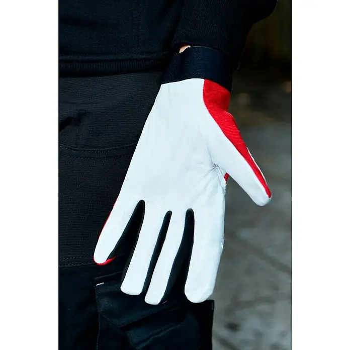 Guide Arbeitshandschuhe 54 PP - Rot/Weiß, 8 - Nahaufnahme eines weißen Lederhandschuhs mit roten Akzenten, getragen von einer Person in schwarzer Kleidung.