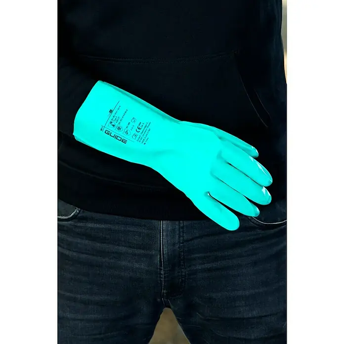 Guide Arbeitshandschuhe 4011 - Grün, 11 - Eine Person trägt blaue GUIDE-Handschuhe und Jeans. Die Handschuhe sind für den Schutz der Hände bei verschiedenen Aufgaben konzipiert.
