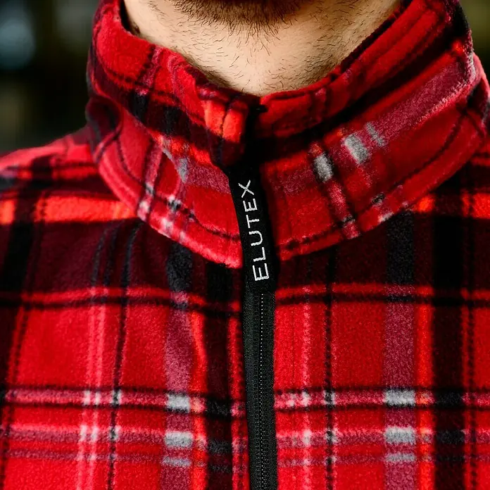 Fleecejacke - Rot/Schwarz, L - Nahaufnahme einer roten Elutex-Fleecejacke mit Reißverschluss und Karomuster.