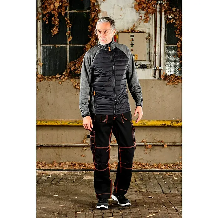 Zekler Schutzbrille 33 - Geeignet für: Brillenträger - Ein Mann in Arbeitskleidung, bestehend aus einer Jacke und Hose, die auf Funktionalität und Stil ausgelegt ist.