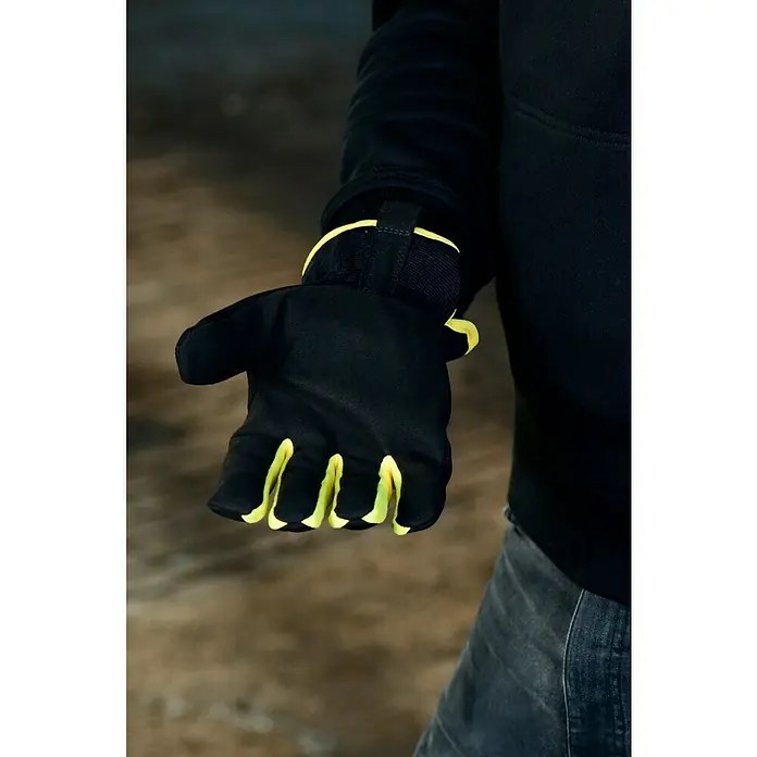 Guide Arbeitshandschuhe 765 - Schwarz/Gelb, 8 - Nahaufnahme eines Mannes, der einen schwarzen Handschuh mit gelben Akzenten trägt und sein Design und seine Passform hervorhebt.