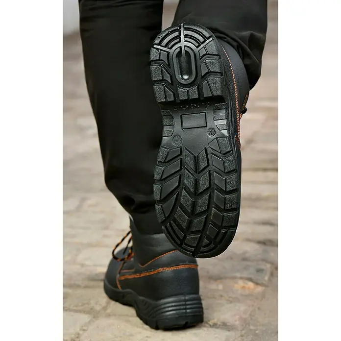 Power Safe Winterstiefel Olaf - Schuhgröße: 41 - Nahaufnahme eines schwarzen Sicherheitsschuhs mit markanter Sohle und orangefarbenen Nähten.