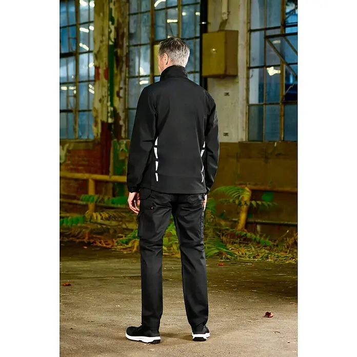 L.Brador Softshell-Jacke 554 P - Schwarz, XS - Ein Mann von hinten, der eine schwarze Arbeitsjacke und eine Hose trägt, perfekt für den professionellen Einsatz.