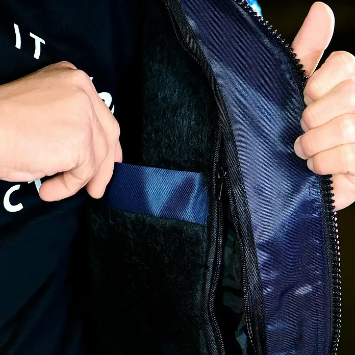 Elutex Piloten-Blouson 4in1 - Navy/Royalblau, XXL - Nahaufnahme einer marineblauen Jacke mit Pelzfutter, die einen Reißverschluss und eine Tasche mit glänzendem blauem Futter zeigt.