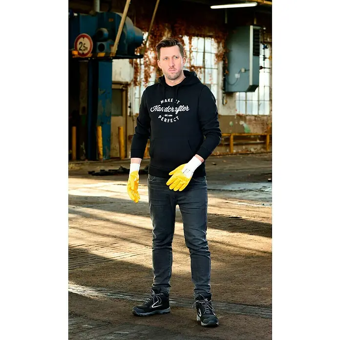 Guide Arbeitshandschuhe 807 PP - Gelb, 11 - Der Mann trägt eine schwarze MAKE IT HANDCRAFTER PERFECT Kapuzenjacke und gelbe Arbeitshandschuhe.