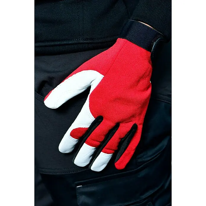 Guide Arbeitshandschuhe 54 PP - Rot/Weiß, 8 - Nahaufnahme eines roten und weißen Arbeitshandschuhs mit schwarzem Innenmaterial auf einer dunklen Hose.