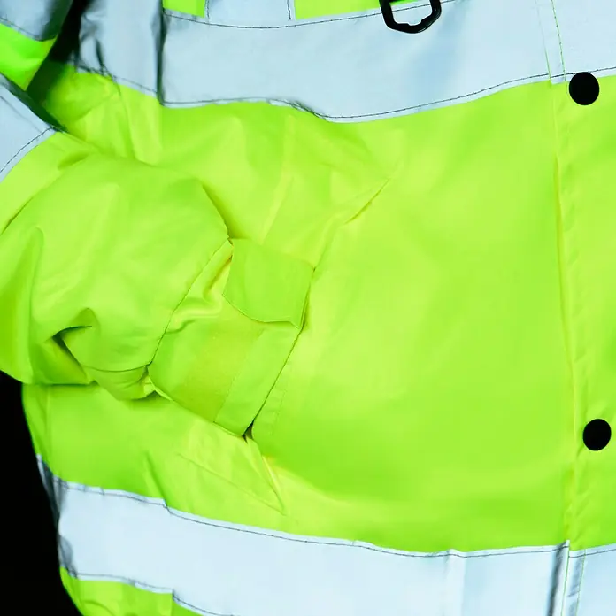 Scheibler Warnschutz-Jacke Blouson - Gelb, XL - Detailaufnahme einer Warnschutzjacke in Neongelb mit reflektierenden Streifen, die hohe Sichtbarkeit und Sicherheit gewährleistet.