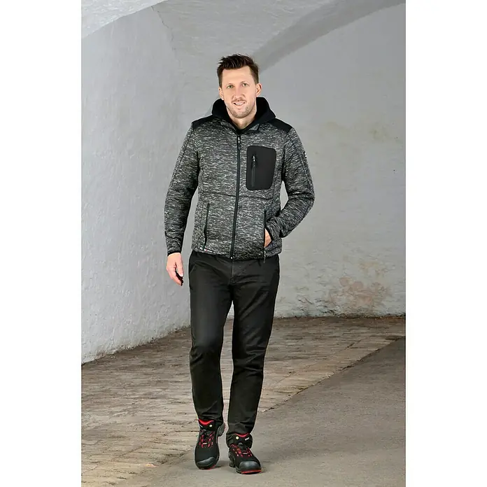 Uvex Sicherheitshalbschuh 1 - 42, Schutzklasse nach EN ISO 20345: S1P, Schwarz/Rot - Ein Mann in Arbeitskleidung, mit einer grauen Fleecejacke mit Kapuze, schwarzen Hose und Sicherheitsschuhen.