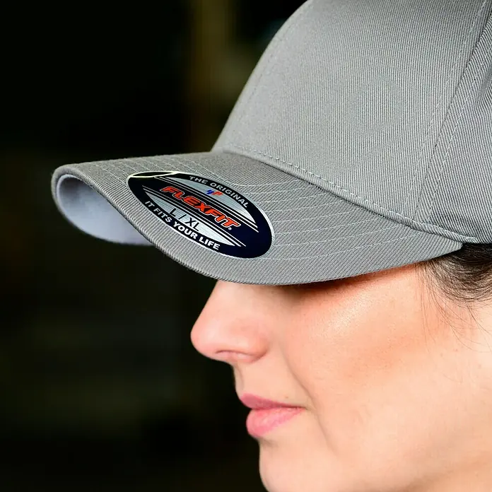 Flexfit Baseballkappe - Grau, XS - Graue Flexfit-Kappe in Größe L/XL mit dem Original-Flexfit-Logo auf dem Schirm, getragen von einer Frau.