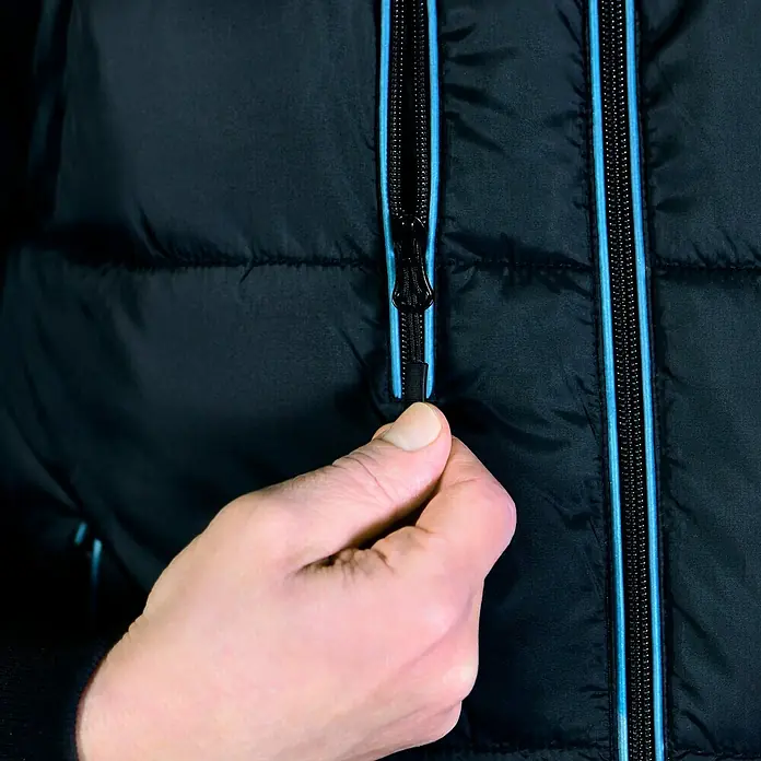 HD Concept Thermoweste - Schwarz/Blau, L - Nahaufnahme einer schwarzen Daunenweste mit blauem Reißverschluss, die von einer Hand bedient wird.