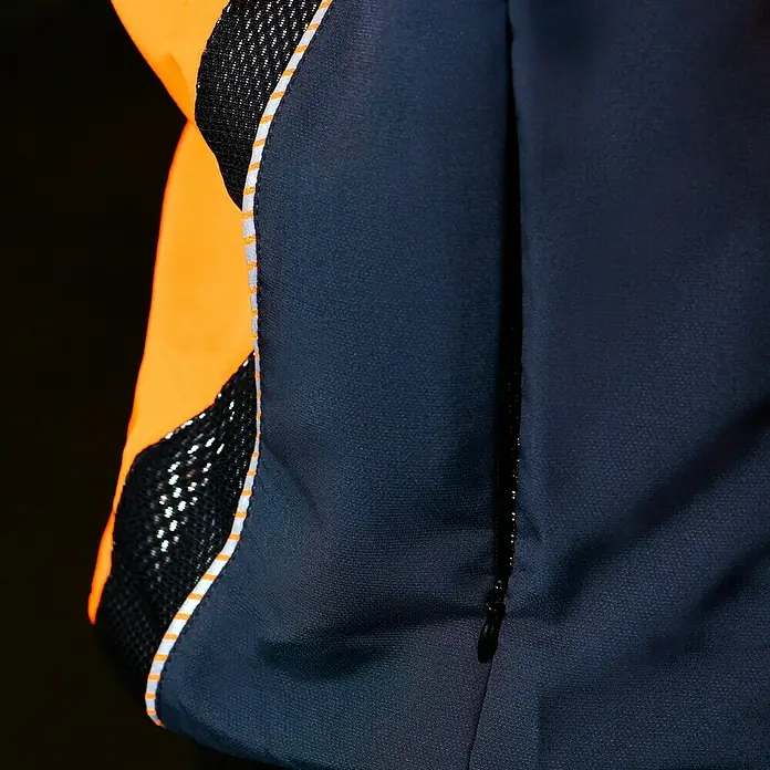 Bullstar Multifunktionsjacke Proximo - Orange/Anthrazit, L - Nahaufnahme einer schwarzen und orangefarbenen Jacke mit reflektierenden Details und einem Reißverschluss.
