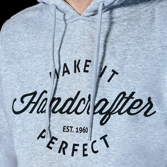 Kapuzenpullover Handcrafter - Grau, Größe: XXXL - Detailaufnahme eines grauen Hoodies mit dem Aufdruck "Make it Handcrafter EST. 1960 Perfect" in schwarzer Schrift.