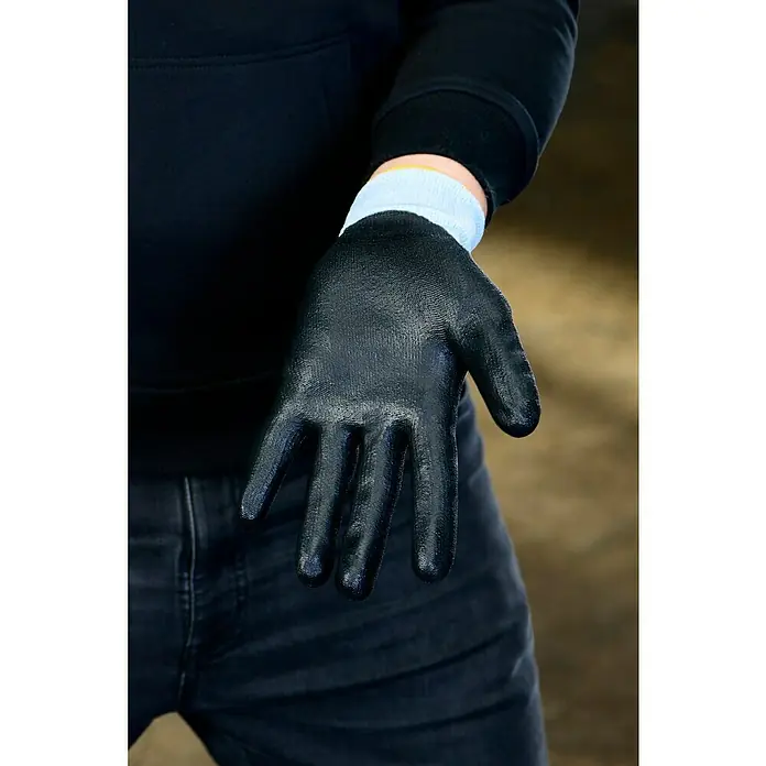 Guide Arbeitshandschuhe 308 PP - Grau, 8 - Nahaufnahme einer Hand mit einem schwarzen Arbeitshandschuh und einem blauen Bündchen. Ideal für sicheres Arbeiten im Garten oder Handwerk.