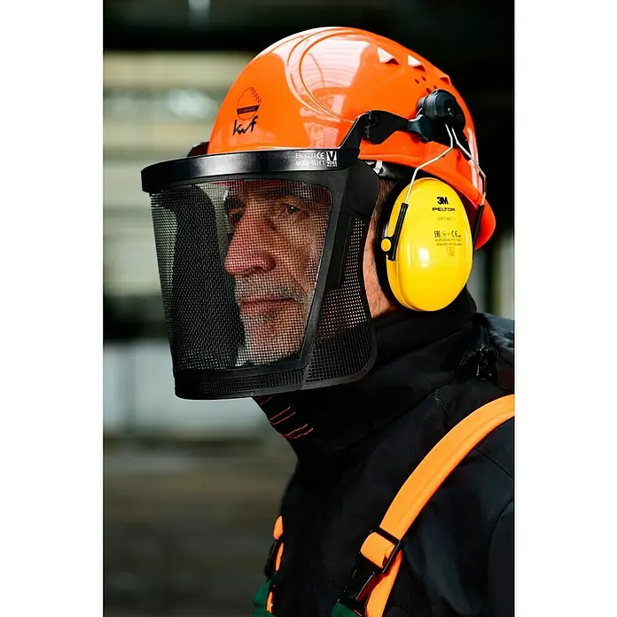 Bullstar Forst-Schutzhelm Peltor Master - Orange - Nahaufnahme eines Mannes mit orangefarbenem Schutzhelm, Gesichtsschutz und gelbem Gehörschutz.