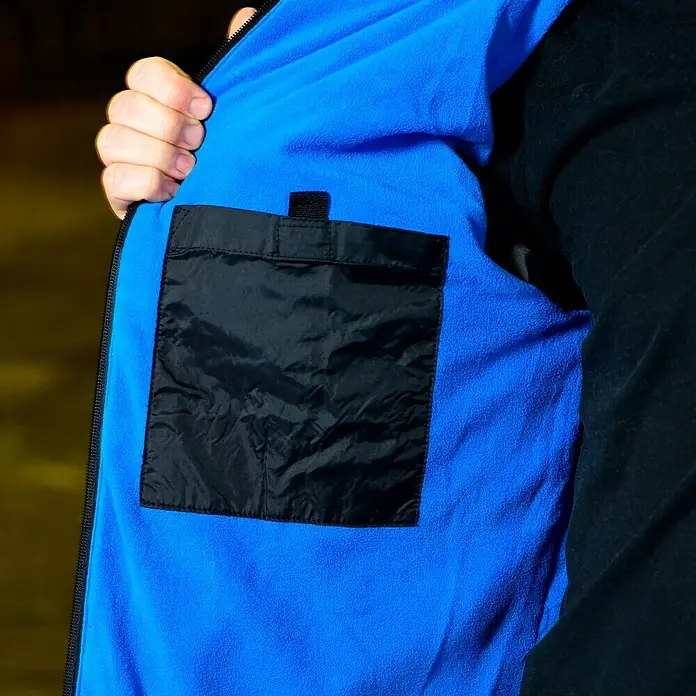 HD Concept Thermojacke - XL, Blau/Schwarz - Aufnahme der Innenseite einer blauen Jacke mit einer schwarzen Tasche und einem schwarzen Ärmelteil.