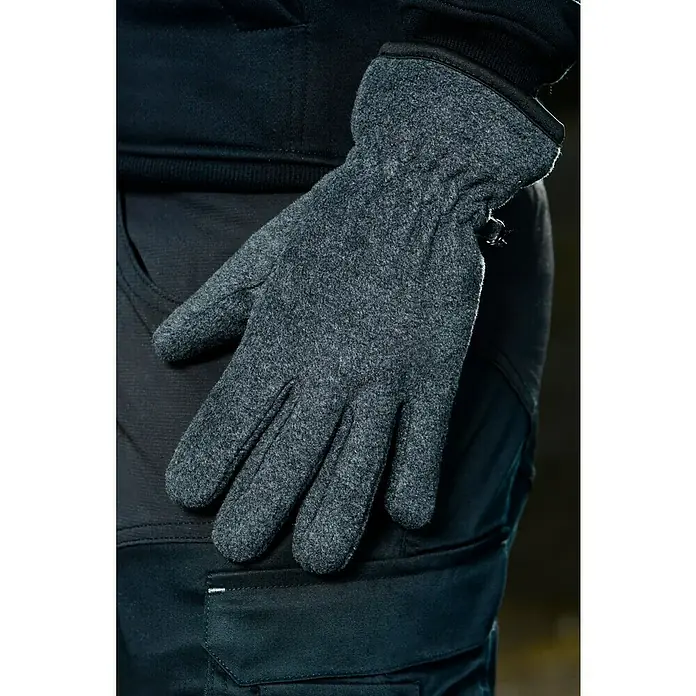 Elutex Winterhandschuhe - XL, Grau - Nahaufnahme eines Mannes, der einen grauen Wollhandschuh trägt, der sich von seiner dunklen Hose und seinem Oberteil abhebt.