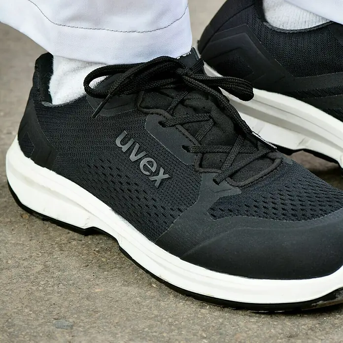 Uvex Sicherheitshalbschuh 1 Sport - 42, Schutzklasse nach EN ISO 20345: S1 - Schwarze Uvex-Sneaker mit weißen Sohlen, ideal für Arbeit und Freizeit. Bequeme und sichere Schuhe für den täglichen Gebrauch.