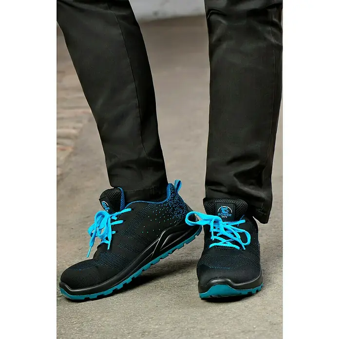 Sicherheitshalbschuh Bluestar S1 - Schuhgröße: 44, S1 - Nahaufnahme von schwarzen Sicherheitsschuhen mit blauen Akzenten und Schnürsenkeln, die auf einer grauen Oberfläche stehen.