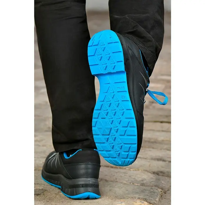 Uvex 2 Trend Sicherheitshalbschuh S3 - 42, Schutzklasse nach EN ISO 20345: S3, Schwarz/Blau - Das Bild zeigt die Sohle eines schwarzen Uvex-Schuhs mit blauem Profil, der Halt und Komfort bietet. Ideal für Arbeit und Freizeit.