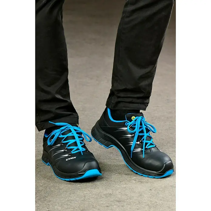 Uvex 2 Trend Sicherheitshalbschuh S3 - 46, Schutzklasse nach EN ISO 20345: S3, Schwarz/Blau - Nahaufnahme von schwarzen Uvex-Sicherheitsschuhen mit blauen Schnürsenkeln, die für Komfort und Schutz bei der Arbeit konzipiert sind.