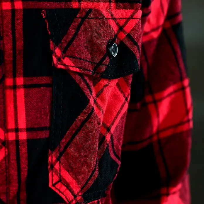 Brandit Flanellhemd - Schwarz/Rot, XXXL - Nahaufnahme einer karierten roten und schwarzen Flanelljacke mit einer Brusttasche, die mit einem Knopf verschlossen ist.