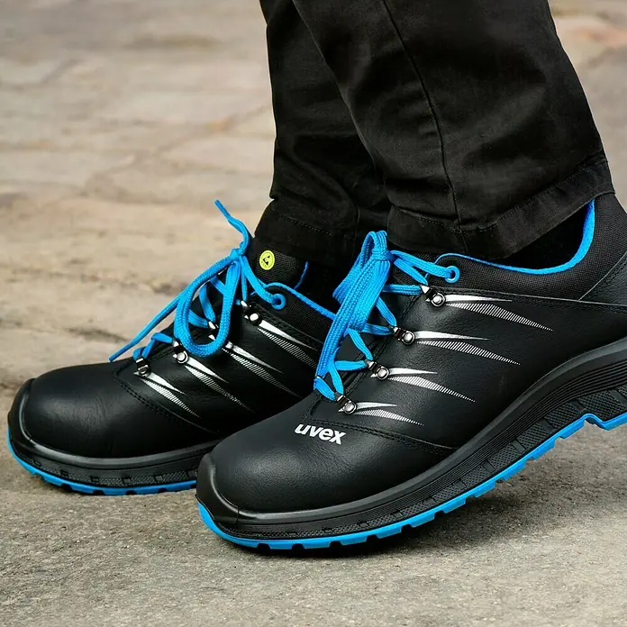 Uvex 2 Trend Sicherheitshalbschuh S3 - 46, Schutzklasse nach EN ISO 20345: S3, Schwarz/Blau - Nahaufnahme von Uvex-Sicherheitsschuhen in Schwarz mit blauen Akzenten und Schnürsenkeln, ideal für den Arbeitsschutz.