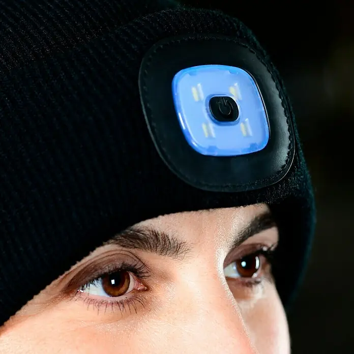Steuber LED-Mütze - Schwarz, Ohne Bommel - Nahaufnahme einer schwarzen Strickmütze mit integrierter, quadratischer LED-Leuchte, die blau leuchtet.
