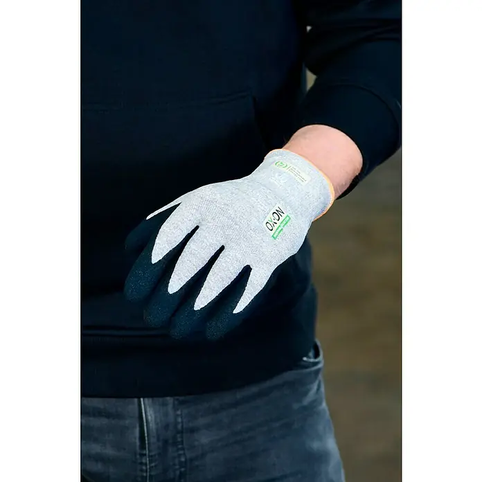 OX-ON Arbeitshandschuhe Recycle Comfort 16302 - Grau, 10 - Grauer OXON Arbeitshandschuh mit schwarzer Handfläche. Der Handschuh hat eine orangefarbene Manschette und ein umweltfreundliches Design.