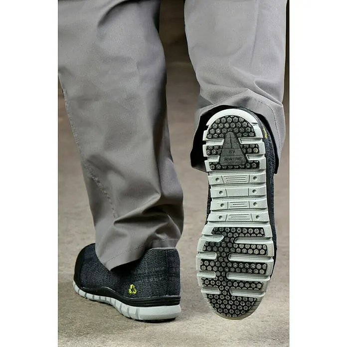 Safety Jogger Sicherheitshalbschuh Morris S1P - 45, Schutzklasse nach EN ISO 20345: S1P, Schwarz - Eine Nahaufnahme von rutschfesten Arbeitsschuhen mit grauer Hose. Ideal für sicheres Arbeiten in anspruchsvollen Umgebungen.