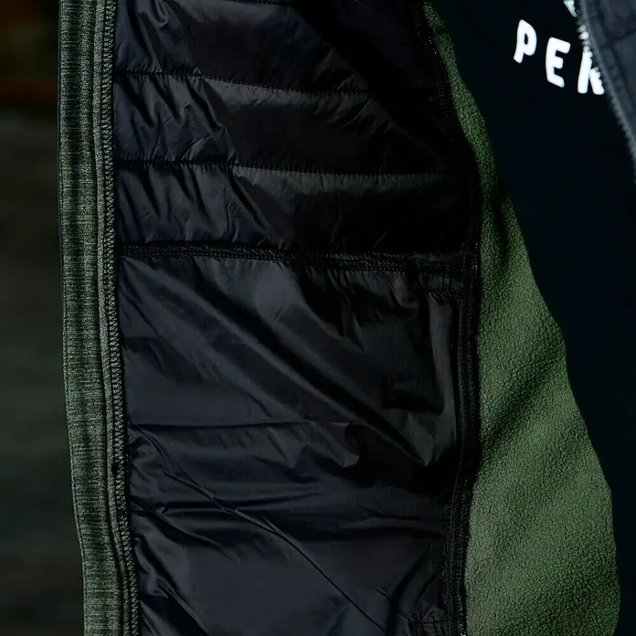 L.Brador Hybridjacke 6090P - Schwarz/Grün, S - Detailansicht des Innenfutters einer grünen Peak Performance Jacke, das gesteppt und schwarz ist. Ideal für Komfort und Wärme.