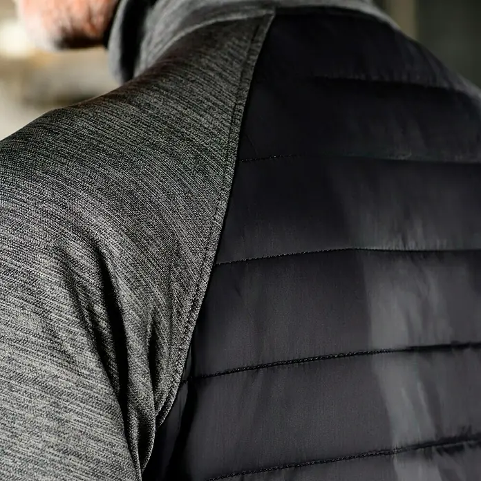 L.Brador Hybridjacke 6090P - Schwarz/Grau, L - Detailaufnahme der Rückseite einer Jacke mit grau melierten Ärmeln und einer schwarzen, gesteppten Weste.