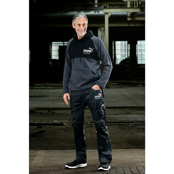 Puma Workwear Kapuzenpullover Champ - Stahlgrau, Carbon, Größe: S - Mann trägt Puma Workwear Hoodie und Hose.