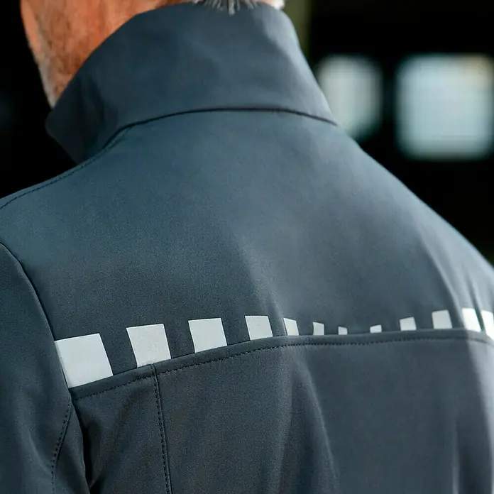 Puma Workwear Softshell-Jacke Champ - Stahlgrau, Carbon, S - Rückansicht einer dunkelblauen Jacke mit reflektierenden Quadraten für erhöhte Sichtbarkeit und Sicherheit bei schlechten Lichtverhältnissen.