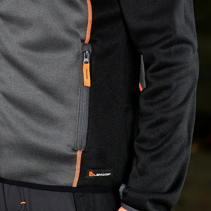 L.Brador Fleecejacke 6195P - Schwarz/Grau, XL - Detailansicht einer grauen und schwarzen Labrador-Fleecejacke mit orangefarbenen Akzenten und Reißverschluss.