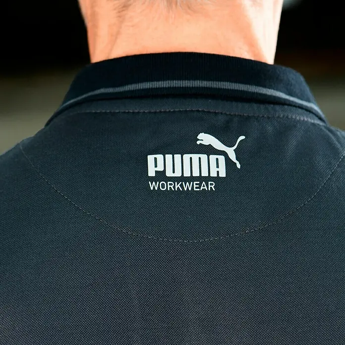 Puma Workwear Poloshirt Champ - Stahlgrau, Carbon, S - Nahaufnahme eines schwarzen Puma Workwear Polo-Shirts mit weißem Logo und Schriftzug am Nacken.