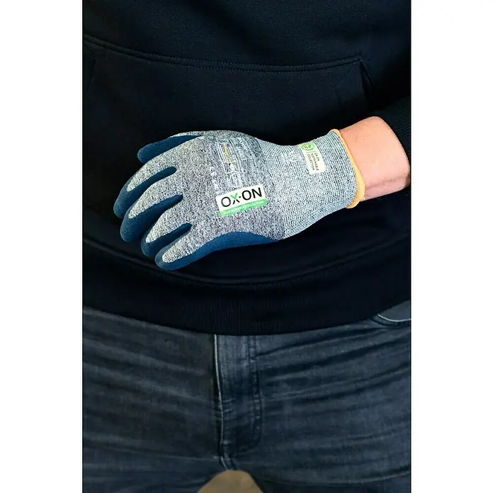 OX-ON Arbeitshandschuhe Recycle Basic 16003 - Grau, 8 - Nahaufnahme eines OX-ON-Handschuhs am Arm einer Person, der Tragekomfort und Schutz bei der Arbeit bietet.