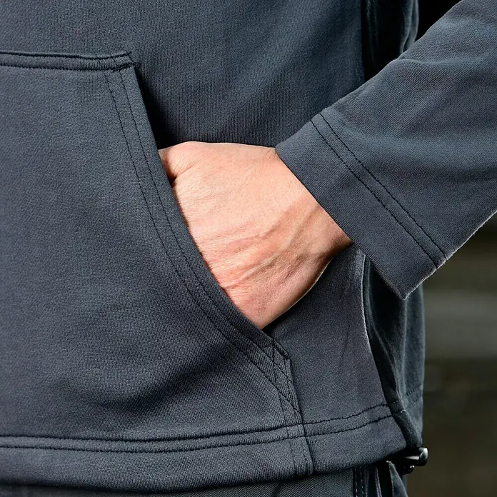 Puma Workwear Kapuzenpullover Champ - Stahlgrau, Carbon, Größe: S - Detailaufnahme eines grauen Hoodies mit Hand in der Tasche. Der Hoodie ist aus hochwertigem Material gefertigt und bietet hohen Tragekomfort.